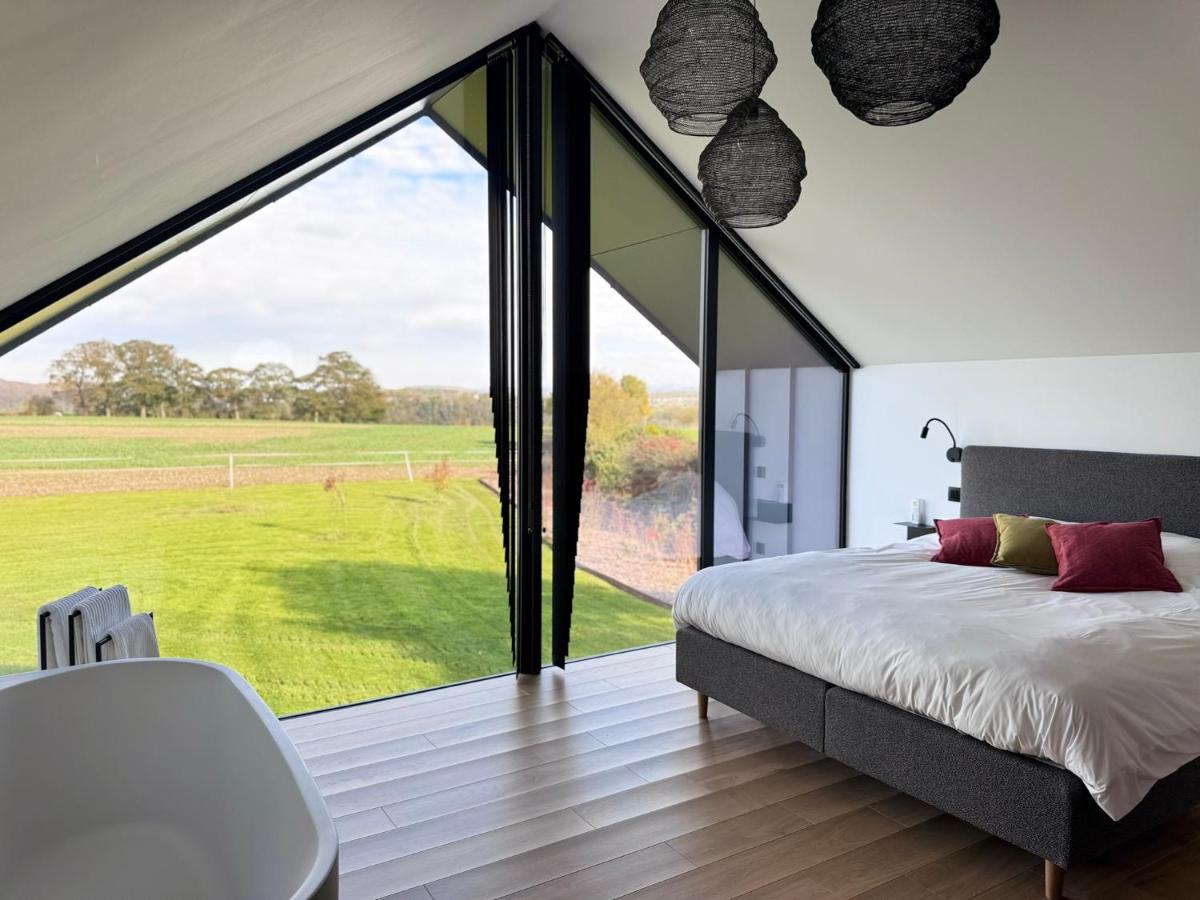 a bedroom with a large window with a large bed at Durbuy insolite - Romantic Escape in Durbuy