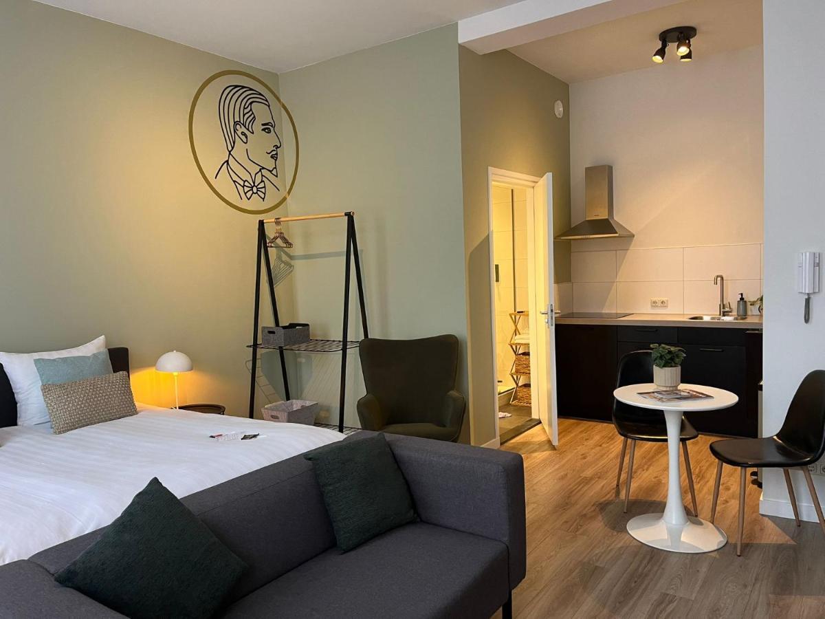 a bedroom with a bed and a couch and a kitchen at Alex Maastricht in Maastricht