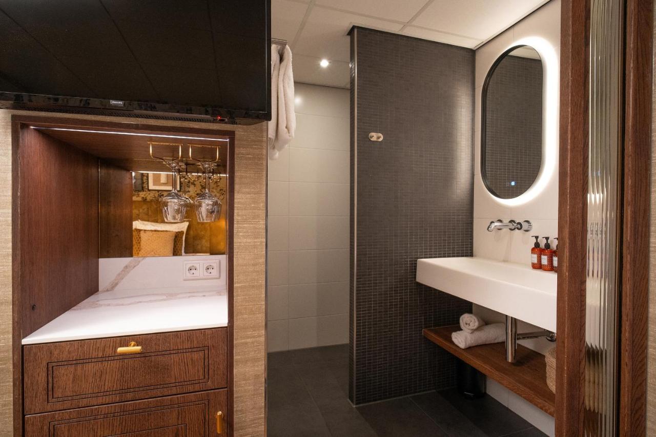 a bathroom with a sink and a mirror at Boutique Hotel De Smulpot in Den Burg