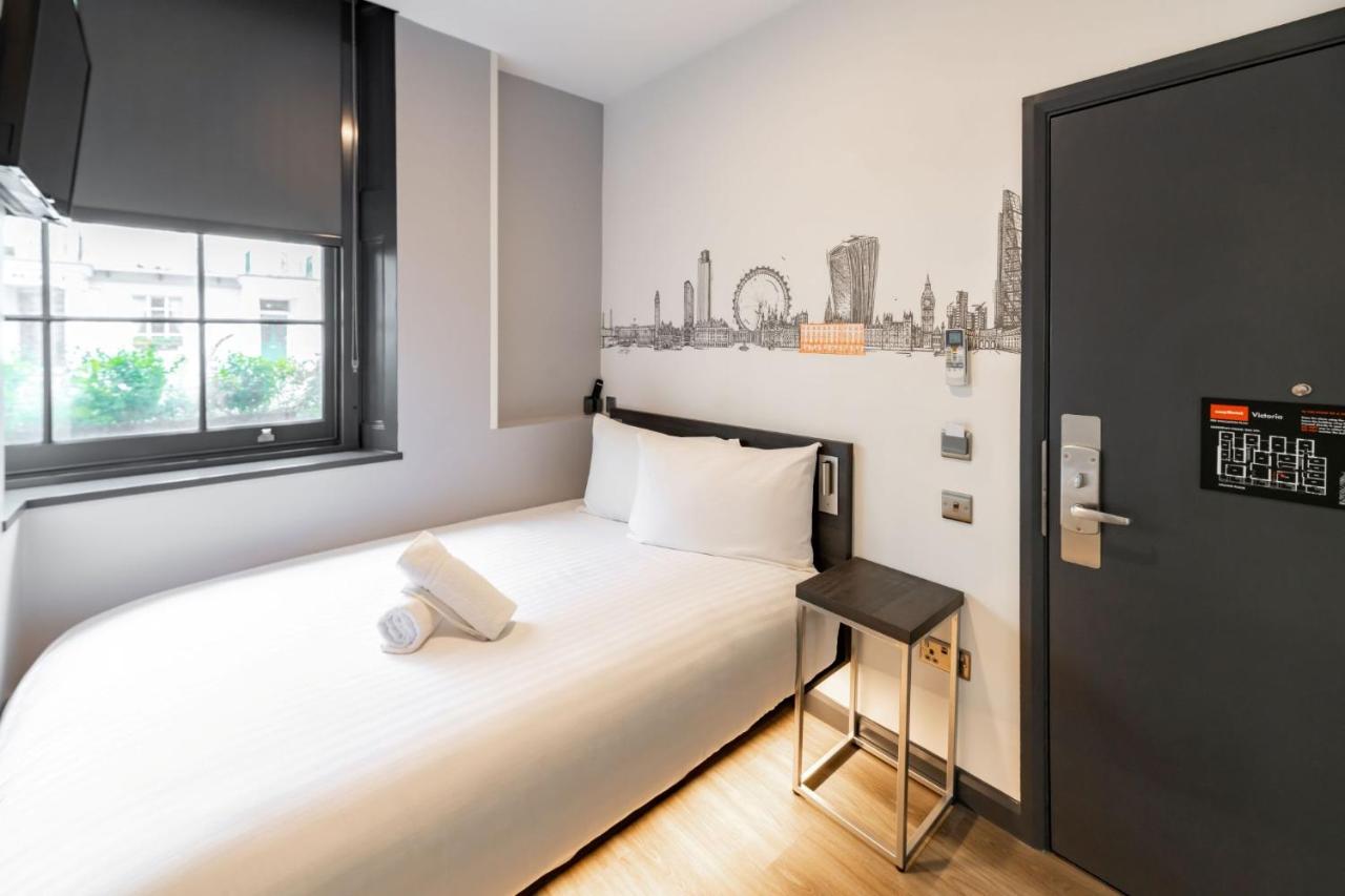 a small bedroom with a white bed and a window at easyHotel Victoria in London