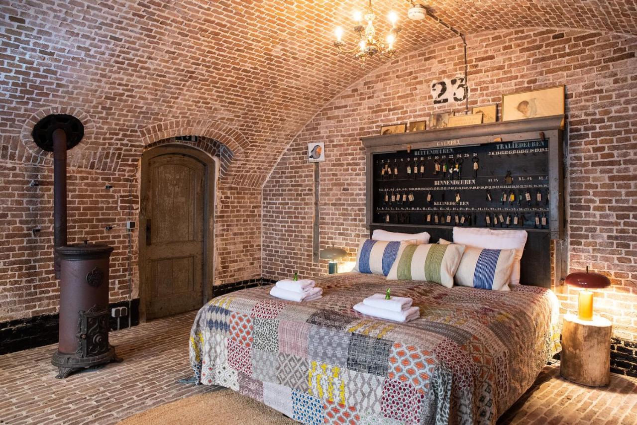 a bedroom with a bed in a brick wall at Fort Vuren in Vuren