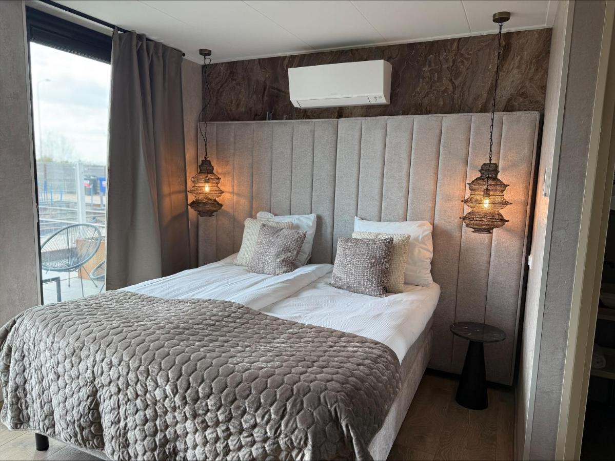 a bedroom with a large bed with two pillows at Hotel Biesbosch in Drimmelen