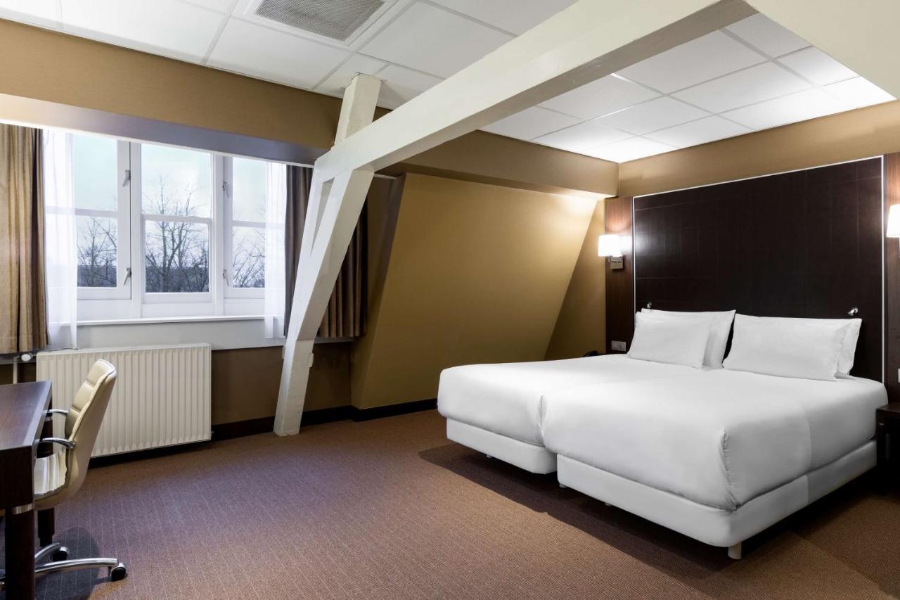 Een bed of bedden in een kamer bij NH Centre Utrecht Hotel
