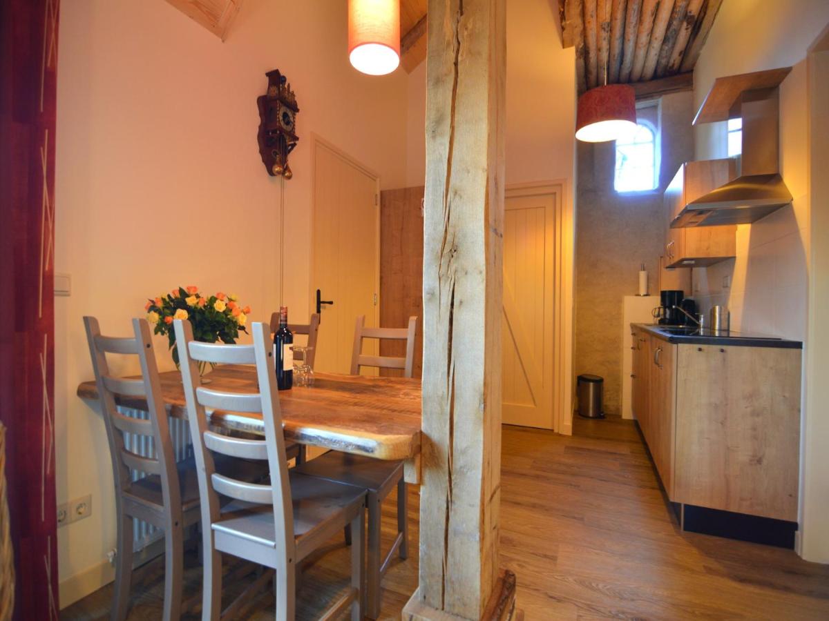 a kitchen and dining room with a wooden table and chairs at Staying in a thatched barn with bedroom Achterhoek in Geesteren