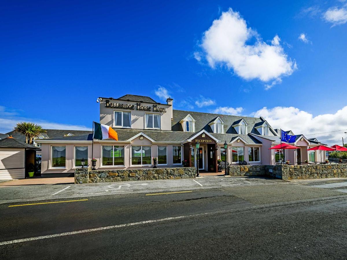 Exterior view of Bellbridge House Hotel under clear blue sky.