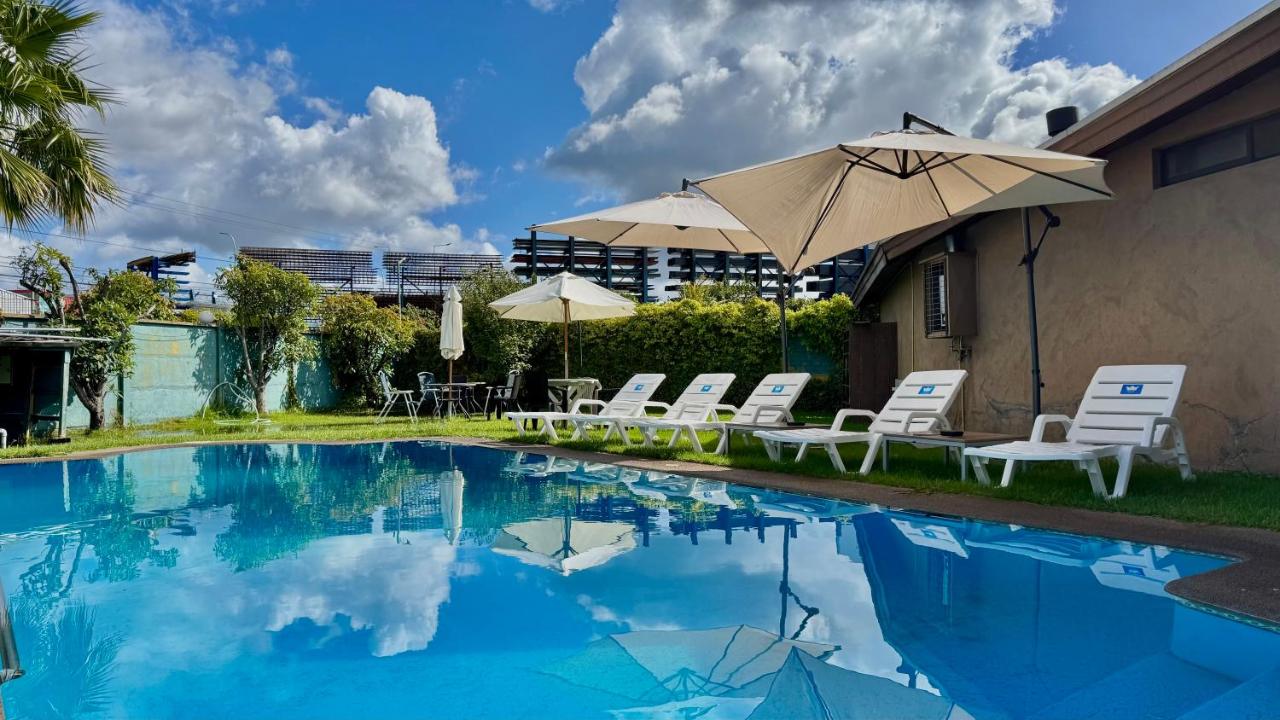 Piscina con sillas y sombrilla en Hotel Econohotel
