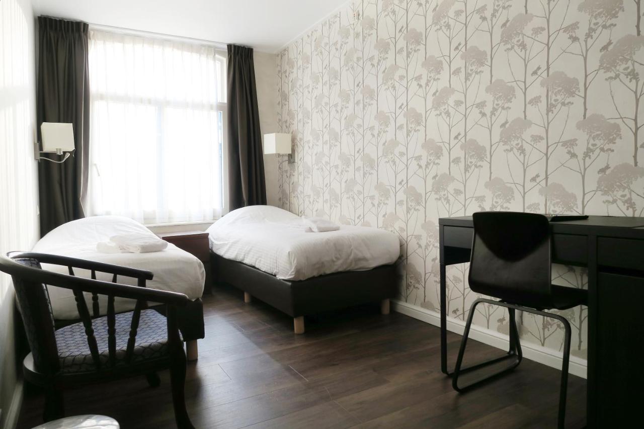Een bed of bedden in een kamer bij Hotel Carillon
