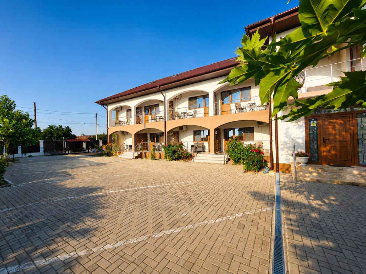 Fațada Casei Coco la apus: două niveluri, arcade la parter, balcoane, curtea pavată