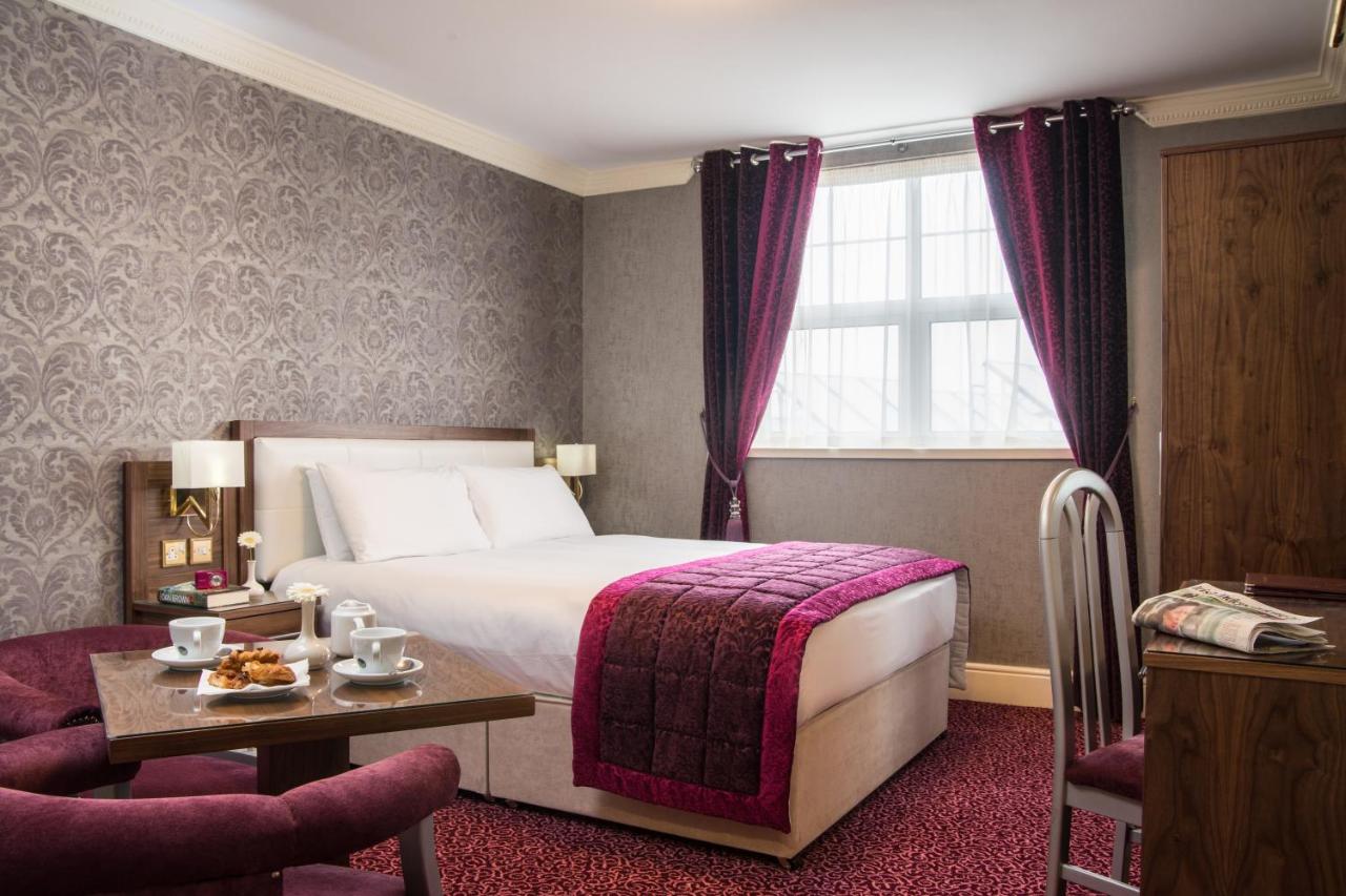 Cozy hotel room with a double bed, table, and tea set.