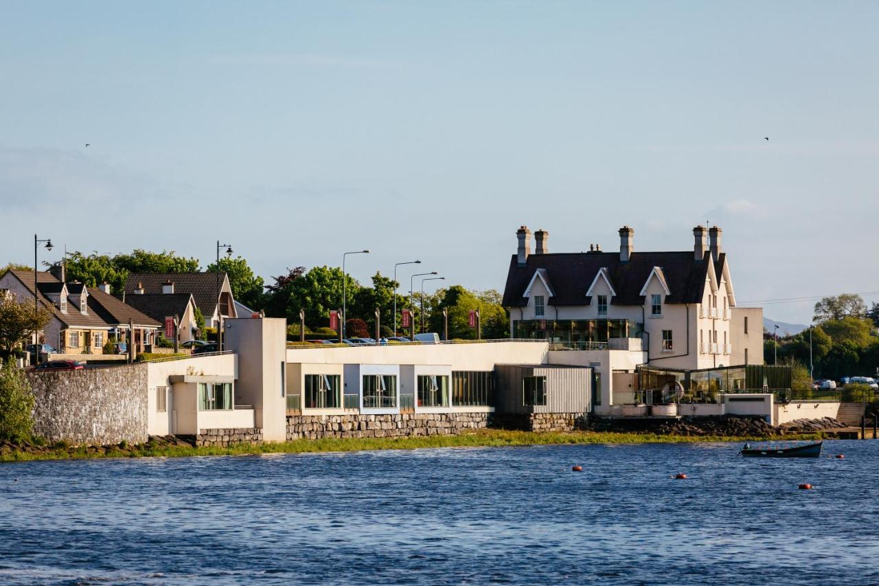 Buildings by a waterfront on a sunny day with a small boat in the water.