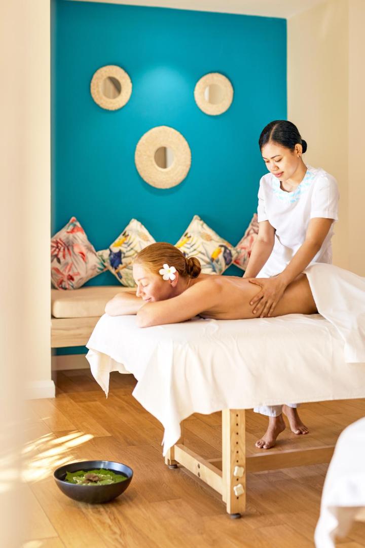 Sieviete bauda relaksējošu muguras masāžu viesnīcas spa centrā.