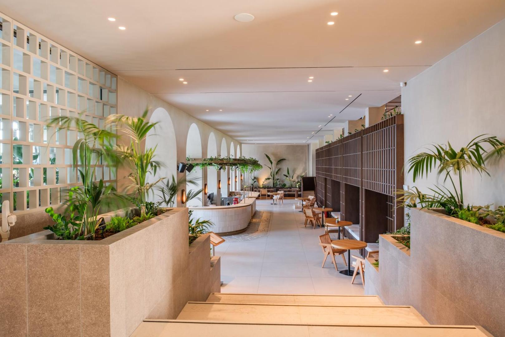 Viesnīcas vestibils un bārs ar modernu interjeru un telpaugiem.