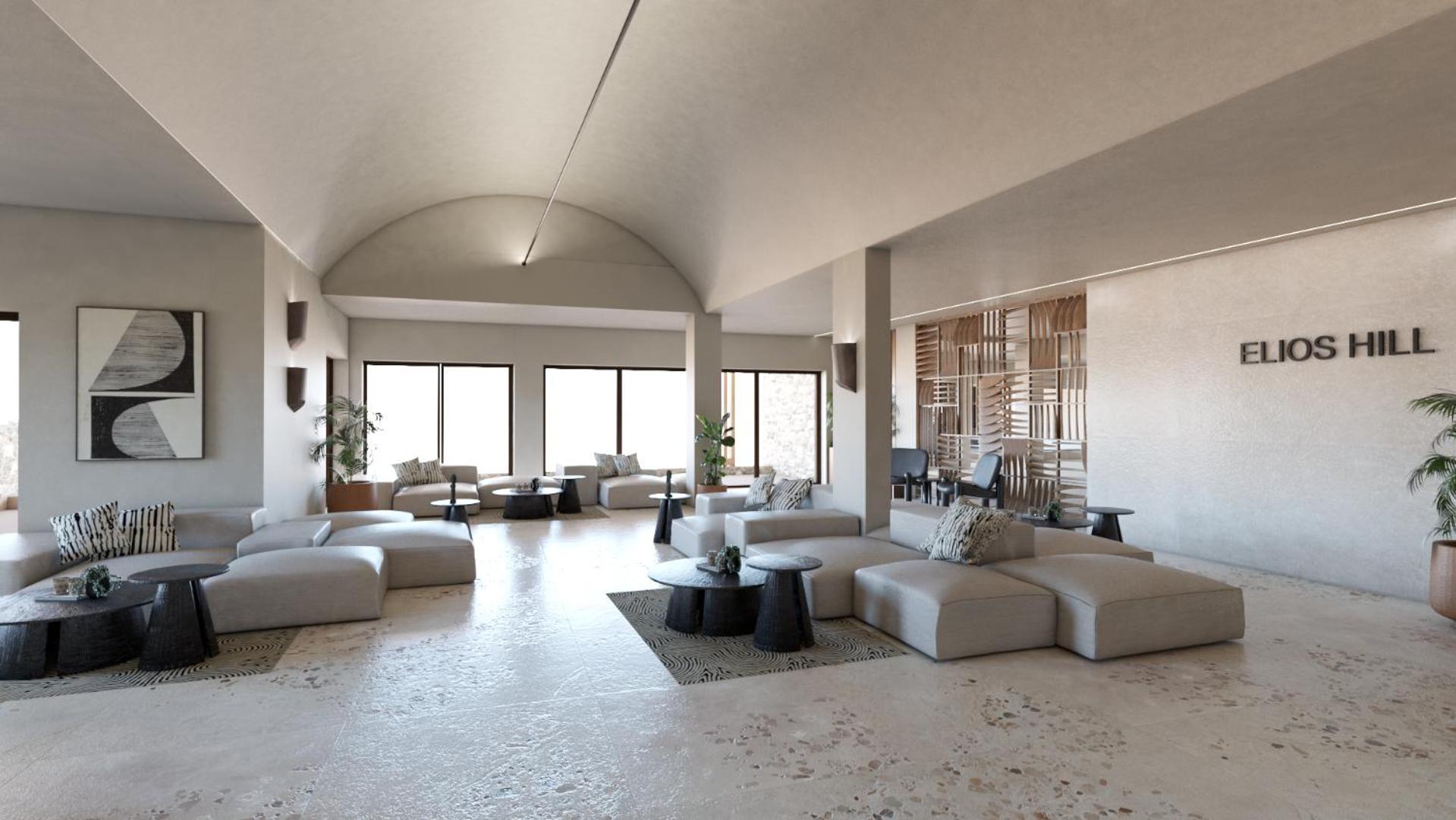 Plašs un gaišs Elios Hill viesnīcas vestibils ar ērtām dīvānu zonām.