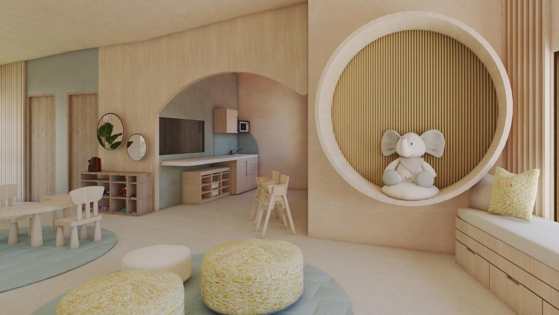 Mājīga bērnu rotaļu telpa ar koka apdari, mīkstiem sēžammaisiem un rotaļlietu zilonīti.