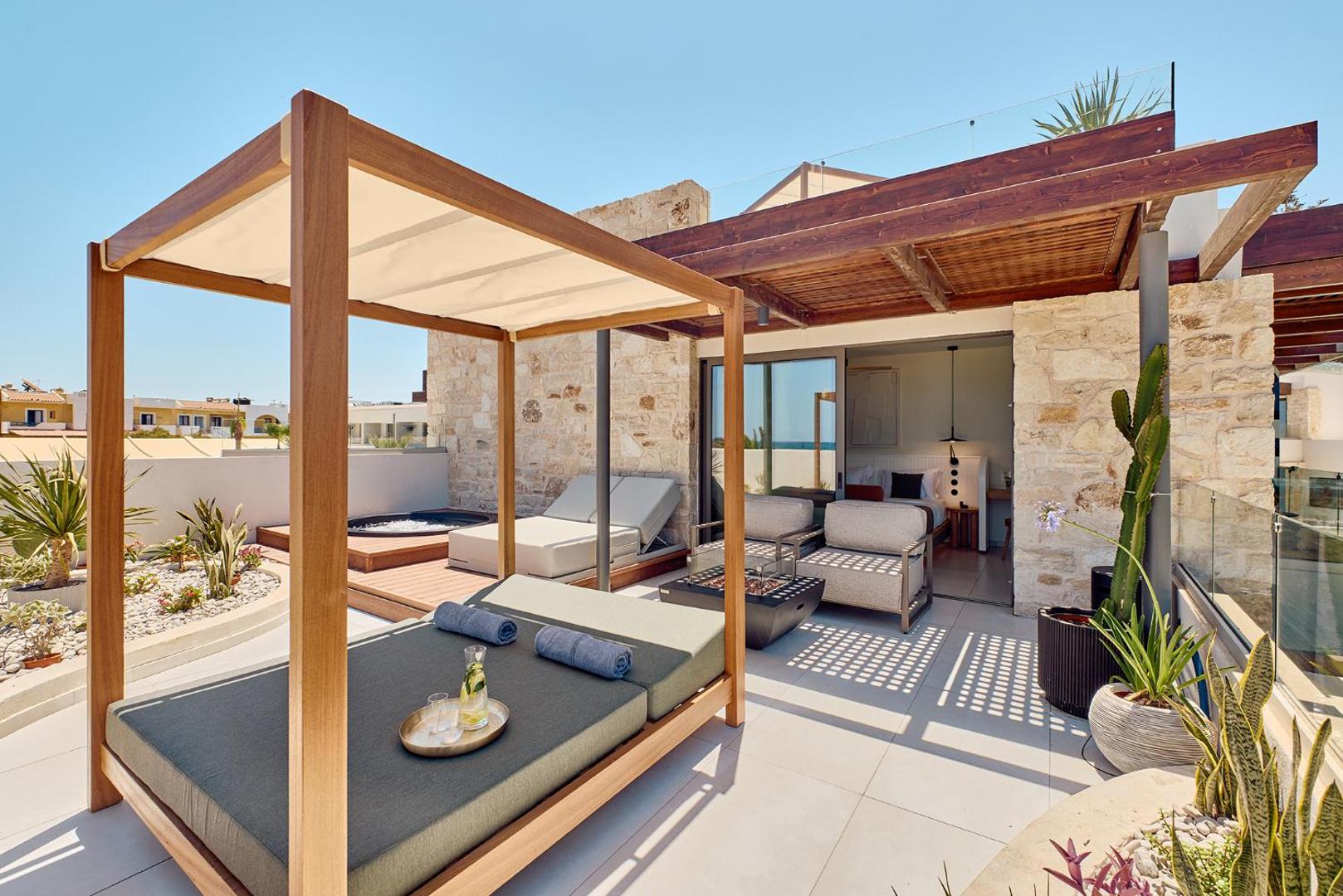 Privāta terase ar atpūtas gultu un skatu uz viesnīcas numuru.