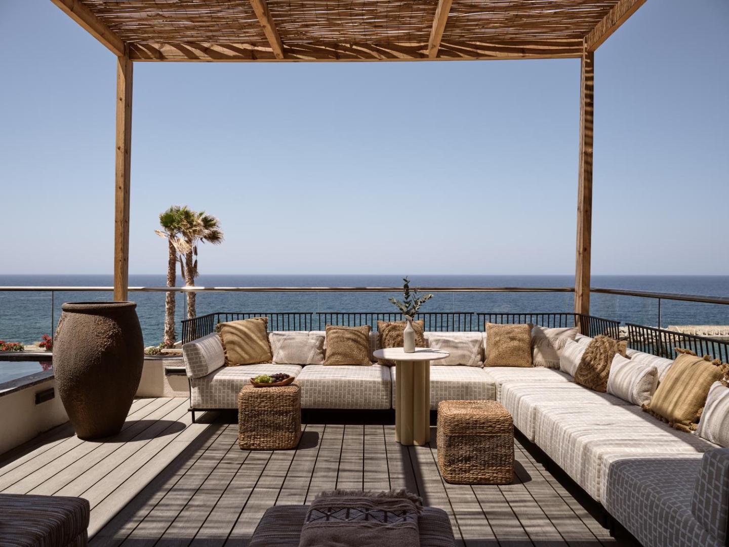 Plaša āra atpūtas zona ar mīkstiem dīvāniem un panorāmas skatu uz jūru.