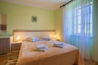 a bedroom with a large bed with two towels on it at Rooms Kučić in Cres