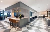 a kitchen with a counter and bar with stools at CityNorth Hotel & Conference Centre in Gormanston