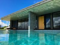 a house with a swimming pool in front of a building at Sesoko Sansui in Sesoko