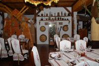 un comedor con mesas y sillas en una sala con estantes para vinos en Туристично розважальний комплекс "Стіжок", en Berkhomet-pe-Siret