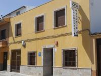 un edificio amarillo con un cartel en el costado en La Posada De Sancho, en Tomelloso