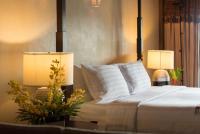 a bedroom with a bed and two lamps on a table at Panviman Resort Koh Phangan - SHA Extra Plus in Thong Nai Pan Noi
