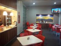 a restaurant with tables and red chairs and a bar at Hotel Block Suites in Mexico City