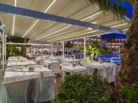 a dining room with white tables and chairs at H10 Cambrils Playa in Cambrils