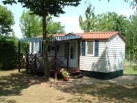 un pequeño cobertizo con un porche y un árbol en Mobilhome Angel, en Cavallino-Treporti