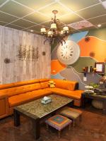 an orange couch in a room with a clock on the wall at Kimoge Homestay in Hualien City