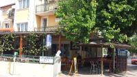 a restaurant with tables and chairs in front of a building at Restaurant &amp; rooms Visovac - best value in Skradin