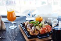 a plate of food on a table with a glass of orange juice at Qasr Al Sahab in Khamis Mushayt