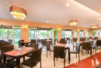 een restaurant met houten tafels en stoelen en ramen bij Krabi Front Bay Resort in Krabi town