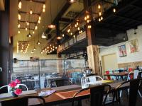 Un comedor con mesas, sillas y luces. en B&B Bela Vrba, en Bačko Novo Selo