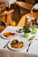 a table with plates of food and a glass of orange juice at Gostiny Dvor Hotel in Kharkiv