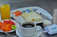 a table with a plate of food and a cup of coffee at Jesens Inn II in Kuta
