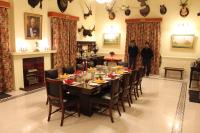 a dining room with a table and chairs and two people at Brijraj Bhawan Palace Hotel in Kota