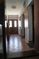 an empty hallway with doors and a tile floor at Guest House Stara Baranja in Kneževi Vinogradi