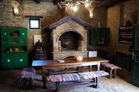 a kitchen with a table and a brick oven at Guest House Stara Baranja in Kneževi Vinogradi