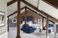 a bedroom with a bed and two blue chairs at Giles Norman Gallery &amp; Townhouse in Kinsale