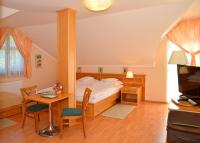 A bed or beds in a room at Vadászkürt Panzió