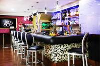 a bar with black stools in a restaurant at Hotel Años 50 in Torremolinos