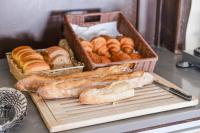 a table with two baskets of bread and pastries at Hotel Atlantique in Mimizan-Plage