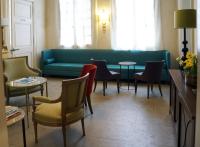 a living room with a green couch and chairs at La Maison d&#39;Uzès Relais &amp; Châteaux in Uzès