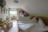 a woman is standing on a bed in a room at Privatzimmer Haring in Kitzeck im Sausal