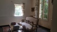 a living room with a chair and a table and a window at Manoir en Crau in Arles