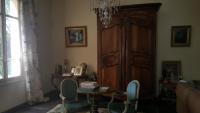 a living room with chairs and a large wooden cabinet at Manoir en Crau in Arles