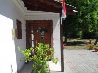 a white house with a wooden door and a plant at Jakuzzis,Szaunás,Kerkavendégház-Őrség-Csesztreg-Kerkaujfalu in Csesztreg