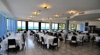 a dining room with white tables and chairs and windows at Hotel Venus in Gabicce Mare