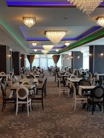 a dining room with tables and chairs and chandeliers at Ramada by Wyndham Constanta in Constanţa
